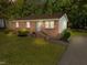 Charming brick home features a well-maintained front yard, mature trees, and inviting entrance stairs at 3016 Fields Dr, Raleigh, NC 27603