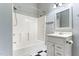Bathroom features a shower-tub combo, a modern vanity, a mirror and black and white tiled floor at 302 N Sumner St, Selma, NC 27576