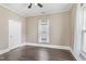 Neutral bedroom featuring a window, white trim, and hardwood flooring at 302 N Sumner St, Selma, NC 27576
