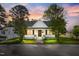 Charming white house with welcoming front porch framed by mature trees under a beautiful twilight sky at 302 N Sumner St, Selma, NC 27576