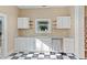 An open-concept kitchen featuring a checkered floor, white cabinets, and stainless steel appliances at 302 N Sumner St, Selma, NC 27576