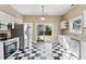 A spacious kitchen featuring white cabinets, stainless steel appliances, and a checkered floor at 302 N Sumner St, Selma, NC 27576