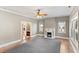 Cozy living room with hardwood floors, decorative fireplace, ceiling fan, and abundant natural light at 302 N Sumner St, Selma, NC 27576
