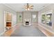 Bright living room with fireplace, large windows, ceiling fan, and hardwood floors at 302 N Sumner St, Selma, NC 27576