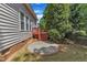 View of the backyard with brick patio, landscaping, and rear deck access at 308 Ravenstone Dr, Cary, NC 27518