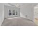 Spacious bedroom with carpeted floors, three windows, and tray ceiling at 308 Ravenstone Dr, Cary, NC 27518