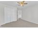 Bright bedroom featuring neutral carpet, a ceiling fan, and closet with ample storage at 308 Ravenstone Dr, Cary, NC 27518