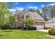 Charming two-story brick home with well-manicured lawn and lush landscaping at 308 Ravenstone Dr, Cary, NC 27518