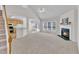 Spacious living room with fireplace, large windows, and view into the kitchen at 308 Ravenstone Dr, Cary, NC 27518