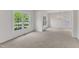 Bright living room features carpeted flooring, a chandelier, and large windows at 308 Ravenstone Dr, Cary, NC 27518