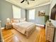 Cozy bedroom featuring hardwood floors, neutral walls, a ceiling fan, and ample natural light from two windows at 309 19Th St, Butner, NC 27509