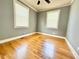 Empty bedroom with hardwood floors, neutral walls, a ceiling fan, and ample natural light from two windows at 309 19Th St, Butner, NC 27509