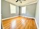 Empty bedroom featuring hardwood floors, neutral walls, a ceiling fan, and ample natural light from two windows at 309 19Th St, Butner, NC 27509