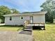 Charming home exterior with a small deck, grey siding, a new roof and a well-maintained lawn at 309 19Th St, Butner, NC 27509