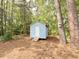 Exterior of a shed with light blue siding, a simple door, and nestled among mature trees and natural surroundings at 309 19Th St, Butner, NC 27509