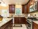Kitchen featuring dark wood cabinetry, granite countertops, and stainless steel appliances at 315 King George Loop, Cary, NC 27511
