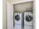 This laundry room features a washer and dryer with storage shelves at 315 King George Loop, Cary, NC 27511
