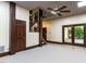 Open-concept living room with dark wood trim, door to garage, stairs and large ceiling fan at 315 King George Loop, Cary, NC 27511