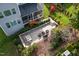 Aerial view of a backyard with a stone patio, dining table, fire pit, wooden playset, and green lawn at 3209 Star Gazing Ct, Wake Forest, NC 27587