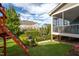 Backyard with playset, shrubs, grass, and an elevated screened porch attached to the home at 3209 Star Gazing Ct, Wake Forest, NC 27587