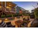 Backyard patio with outdoor seating around a fire pit, with a playset and covered porch in the background at 3209 Star Gazing Ct, Wake Forest, NC 27587