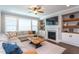 Comfortable living room with a fireplace, built-in shelves, and large windows providing ample natural light at 3209 Star Gazing Ct, Wake Forest, NC 27587