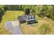 Aerial shot showcasing the charming home, long driveway and large lot surrounded by mature trees at 3214 Saddle Club Rd, Mebane, NC 27302