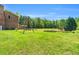 Expansive backyard featuring a wooden swing set, garden, and lush greenery at 3214 Saddle Club Rd, Mebane, NC 27302