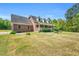 Charming two-story brick home featuring a sprawling lawn and inviting front porch with white railing at 3214 Saddle Club Rd, Mebane, NC 27302
