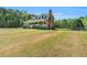 Spacious yard featuring the two-story home with large front porch and a swing set at 3214 Saddle Club Rd, Mebane, NC 27302