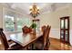 Formal dining room with elegant chandelier, wainscoting, and a large window overlooking the front yard at 3581 Boulder Ct, Wake Forest, NC 27587