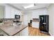 Well-lit kitchen features white cabinets, stainless steel appliances, and hardwood floors at 3581 Boulder Ct, Wake Forest, NC 27587