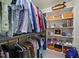 Organized walk-in closet with shelves, hanging space, and orange storage containers at 359 Heather Bluffs Dr, Garner, NC 27529