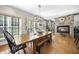 Elegant dining room with a long wooden table, fireplace, and large windows providing ample natural light at 359 Heather Bluffs Dr, Garner, NC 27529
