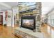 Living room stone fireplace with decorative mantle, glass door, and hardwood flooring at 359 Heather Bluffs Dr, Garner, NC 27529