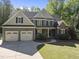 Traditional-style home featuring a three-car garage, manicured lawn, and a welcoming front porch at 359 Heather Bluffs Dr, Garner, NC 27529