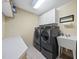Well-equipped laundry room with modern appliances, storage cabinets, and a utility sink at 359 Heather Bluffs Dr, Garner, NC 27529