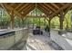Outdoor kitchen area featuring a built-in grill, sink, and ample counter space under a covered pergola at 359 Heather Bluffs Dr, Garner, NC 27529