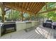 Fully equipped outdoor kitchen with built-in grill, counters, and a covered pergola at 359 Heather Bluffs Dr, Garner, NC 27529