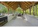 Outdoor kitchen with a built-in grill, countertops, and wooden beams creating a perfect space for entertaining at 359 Heather Bluffs Dr, Garner, NC 27529