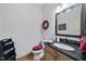 Cozy powder room featuring a granite countertop, framed mirror, red accents, and modern fixtures at 359 Heather Bluffs Dr, Garner, NC 27529