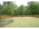 Large fenced backyard featuring healthy green grass and mature trees providing privacy at 3804 Delves Ln, Raleigh, NC 27616