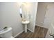 Powder room with pedestal sink, oval mirror, neutral walls, and tile flooring at 3804 Delves Ln, Raleigh, NC 27616