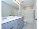 Bathroom with double vanity, tub/shower combo, gray cabinets and a large mirror at 3804 Delves Ln, Raleigh, NC 27616