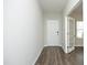 A modern hallway with gray walls, wood-look flooring, and a doorway leading to another room with bright windows at 3804 Delves Ln, Raleigh, NC 27616