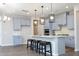 A kitchen with light gray cabinetry, a large island with seating, pendant lighting, and stainless steel appliances at 3804 Delves Ln, Raleigh, NC 27616