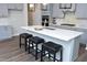 Kitchen island with seating, stainless steel sink, and a view of the cabinets and appliances at 3804 Delves Ln, Raleigh, NC 27616