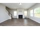 Spacious living room boasts hardwood floors, a fireplace, and bright natural light from the many windows at 3804 Delves Ln, Raleigh, NC 27616