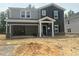 New two-story home featuring an attached garage and a mix of gray and dark siding at 3845 Rosebush Dr, Zebulon, NC 27597