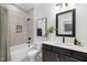 Well-appointed bathroom with a shower-tub combo, dark vanity, and a large mirror, combining style and functionality at 3922 Lost Fawn Ct, Raleigh, NC 27612